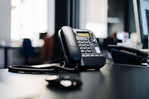 an office phone sits on a corporate desk
